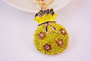 Vue macro détaillée d'un porte-clés bourse jaune en cristaux avec motifs floraux