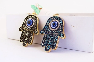 Detail of Hamsa Hand pendants with Evil Eye crystal inlay and enamel gold plating