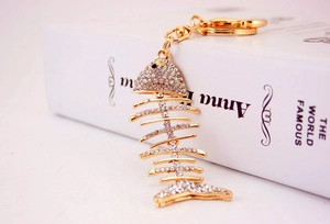 Detailed side view of a sparkling gold fishbone keychain with rhinestones and lobster clasp