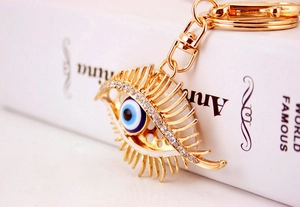 Close-up of golden Evil Eye keychain with sparkling rhinestones and lobster clasp detail