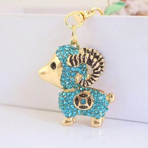 Portachiavi capra dorata con strass blu scintillanti e corna a spirale su sfondo bianco