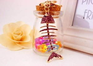 Detail of fish bone keychain with purple crystals and gold-plated spring clasp