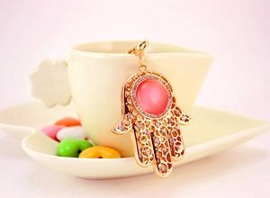 Nahaufnahme Hamsa Hand Schlüsselanhänger in Gold mit rosa Opal und Kristallen