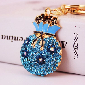 Charming gold-tone lucky money bag keychain with vibrant blue rhinestones and enamel bow