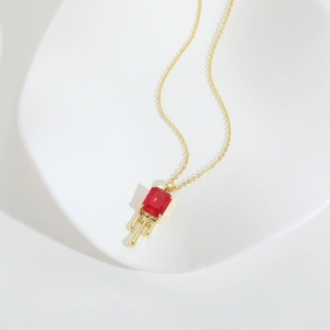 Collana minimalista in oro con gemma rossa rettangolare e design a goccia lava