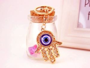 Hamsa-Hand Schlüsselanhänger mit blauer Evil Eye Perle und funkelnden Strasssteinen