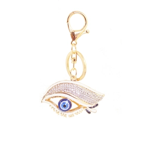 Détail macro du porte-clés œil bleu doré avec strass blancs et émail de qualité