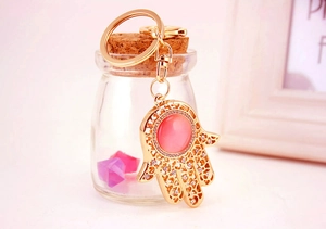 Detailansicht goldener Hamsa Schlüsselanhänger mit rosa Katzenauge und Kristallen