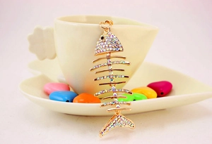 Detail of creative fishbone keychain with sparkling crystal rhinestones and gold finish