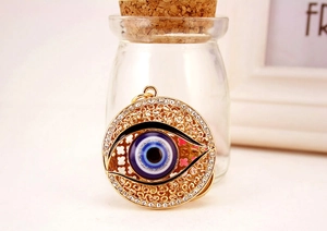 Détail du pendentif œil de protection avec strass et travail délicat du métal doré