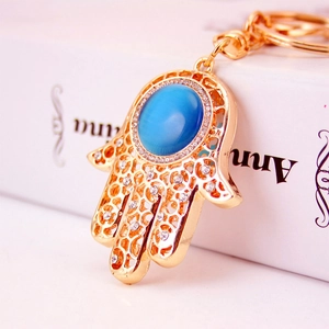 Goldener Hamsa-Hand Schlüsselanhänger mit blauem Edelstein und Strass-Details