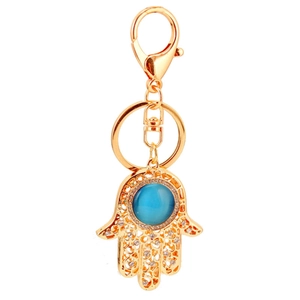 Hamsa Hand Schlüsselanhänger mit blauem Katzenauge und glitzernden Strasssteinen in Gold