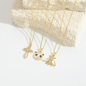 Encantadores collares con colgantes de animales dorados, motivos de panda y abeja en soporte