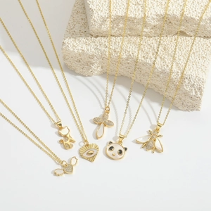 Vista detallada de collares dorados con colgantes de panda, gato y corazón en relieve