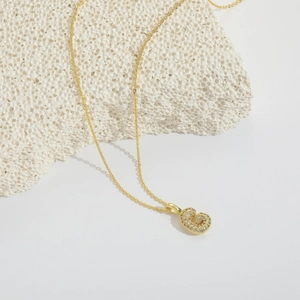 Détail du collier chaîne dorée avec pendentif lettre G serti de zircons étincelants
