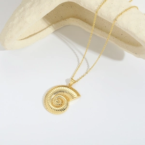 Elegante collar con colgante de concha dorada y circonitas sobre fondo blanco minimalista