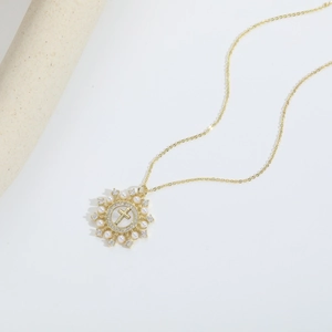 Vintage gold necklace with pearl and diamond cross pendant on minimalist white background