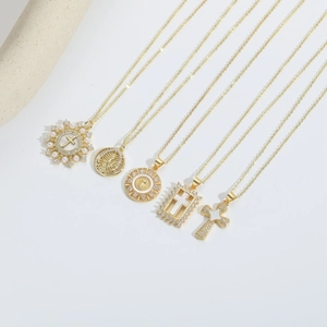 Vintage gold religious cross necklace set with pearls and zircons on grey background