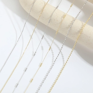 Detailed comparison of various 14k gold plated and silver link chain necklaces on a prop