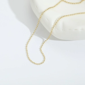 Minimalist 14k gold plated beaded chain necklace for women on white ceramic display