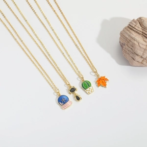 Vintage gold necklaces featuring enamel crystal ball, cat, cactus, and maple leaf charms