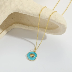 Close-up of golden shell pendant necklace with sky blue enamel finish and fine chain