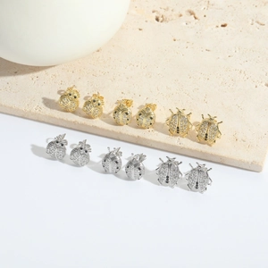 Exquisite gold and silver ladybug stud earrings set with sparkling zircon micro-pave