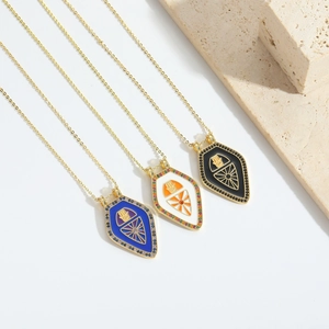 Detail view of colorful enamel shield pendants with intricate inlaid stones and gold chains