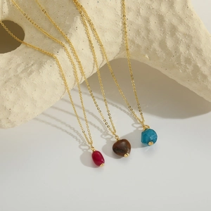Three natural stone pendants in heart and oval shapes on fine gold chains for women