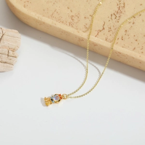 Gros plan détaillé d'un collier doré orné de breloques en résine et cristaux multicolores