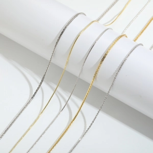 Collares minimalistas en oro y plata presentados sobre soportes blancos redondos