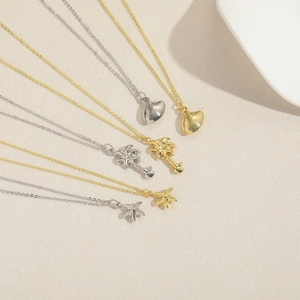 Detail of seashell, palm tree, and starfish pendants in gold and silver finish