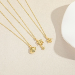 Three gold ocean necklaces featuring coconut tree, starfish and shell pendants