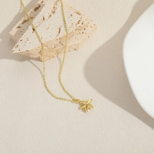 Exquisite gold-plated starfish pendant necklace on travertine stone for elegant resort style