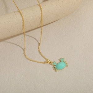 Collana con ciondolo a granchio dorato e smalto azzurro su catena sottile dorata
