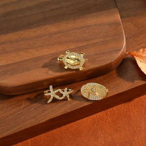 Vintage gold turtle and starfish brooch set with sparkling rhinestones on wood