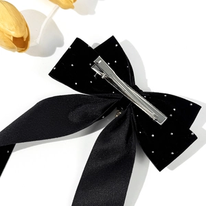 Barrette à cheveux élégante en velours noir avec perles et strass sur fond blanc