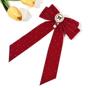 Pince à cheveux élégante en velours rouge avec strass et pendentif perle sur fond blanc