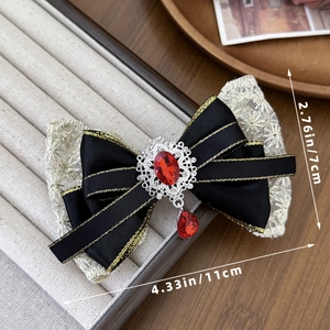 Vintage palace style lace bow hair clip with red rhinestone pendant in a jewelry box