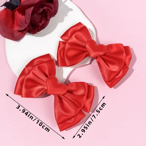 Détail des barrettes nœud en satin rouge avec cœur et dimensions de 10x7,5 cm vues
