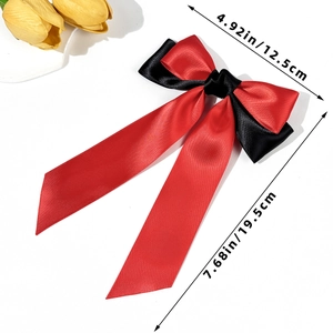Detail view of red and black satin bow hair clip with dimensions 12.5cm by 19.5cm