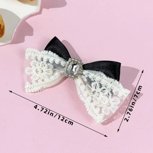 Vue détaillée de la barrette à nœud en dentelle avec strass brillants mesurant 12 cm de long