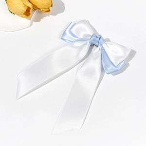 Detailed top view of a dual-layer white and light blue satin ribbon bow hair clip