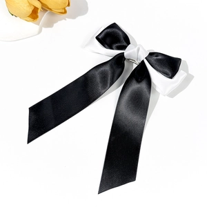 Detail view of the elegant black and white satin bow hair clip with long silk ribbons