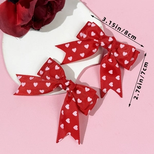 Details von roten Haarschleifen mit rosa Herzen inklusive Maßangaben von 8 cm x 7 cm