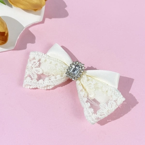 Barrette élégante en dentelle avec nœud et strass luxueux sur un fond rose doux