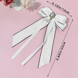 Détail de la pince à cheveux nœud blanc avec fleur de camélia et perles sur rose