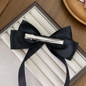Elegant black satin bow hair clip with long ribbons and a silver metal duckbill clip