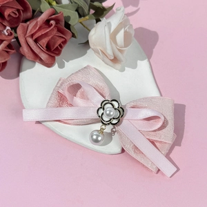 Détail de la barrette à cheveux rose avec fleur de camélia et pendentif en perle