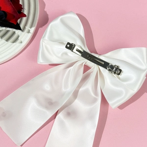 Elegant white satin oversized bow hair clip with a metal spring fastener for women